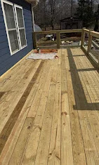 Newly constructed pressure-treated wood deck with border pattern and built-in benches