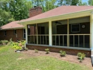 Screened porch with black frame and full screening on brick home