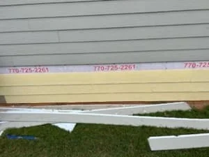 New cream fascia and soffit trim boards measured and staged for roofline installation
