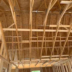 Wood framing with exposed beams, joists, and ceiling grid installation