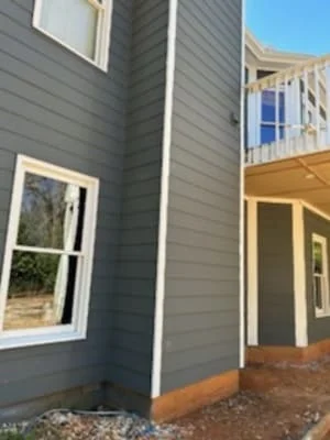 Gray horizontal siding with white trim and windows on residential home exterior