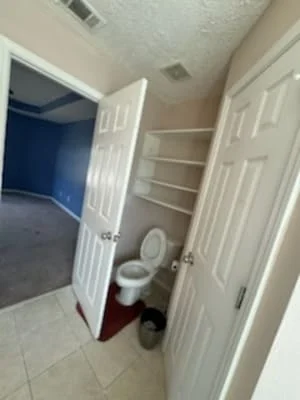 Bathroom with freshly painted beige walls and white trim around doors and shelves