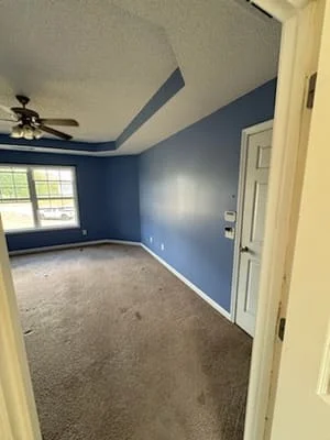 Blue painted bedroom walls with cream trim and painted tray ceiling with angular details