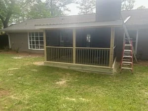 Screened porch with metal framing, screening panels, and composite deck attached to home
